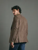 Saco sport de gamuza ecológica, con cierre de dos botones frontales, solapas clásicas y bolsillos laterales con solapa.