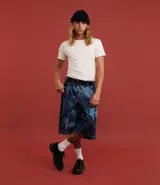 Bermuda de hombre en modelo baggy relaxed, confeccionada en jeans de algodón con estampado manchado en tonos azules. Presenta cintura con trabilla, cierre tradicional y bolsillos.