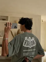Remera oversize gris con efecto acid wash y estampa frontal con la leyenda "WORLDWIDE TOUR" en tipografía gótica.