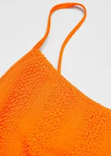 Malla enteriza de color naranja con textura arrugada, escote recto y tirantes finos.