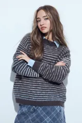 Sweater de tejido de punto con diseño de rayas horizontales en tonos gris oscuro y celeste. Presenta cuello redondo, corte relajado y mangas largas con puños ajustados.