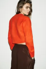 Jersey de punto de cuello redondo y manga larga, con acabado en rib en puños y ruedo.