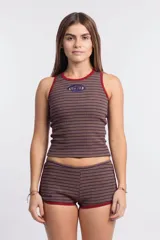 Short de tiro bajo, ajustado al cuerpo, con tejido acanalado a rayas horizontales marrones y azul oscuro. Presenta ribetes de color rojo en la cintura y en el borde de las piernas.