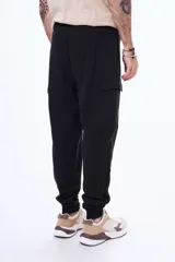 Championes deportivos de estilo urbano, color negro con detalles en gris y suela blanca. Presentan un diseño con cordones y paneles superpuestos.