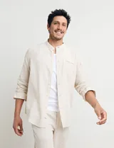 Camisa de cuello mao y manga larga, confeccionada en una mezcla de lino y algodón. Presenta un diseño de corte recto con botones en tono natural y un bolsillo pequeño en el pecho.