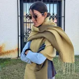 Bufanda de lana color beige con flecos en los extremos.