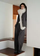 Chaqueta de corte recto estilo sastre, color gris, con cuello de solapa con muesca, cierre frontal de tres botones, bolsillos laterales de ribete y un bolsillo de ribete en el pecho. Cuenta con forro interior y mangas largas.