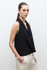 Blusa sin mangas de lino color maíz, con cuello drapeado y diseño fluido.