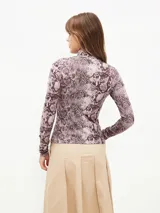 Polera de cuello alto con estampado de piel de serpiente en tonos lila y marrón.