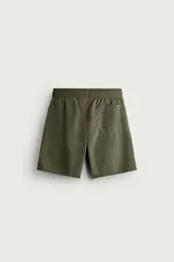 Short de baño largo en color beige, confeccionado en tejido técnico con tacto aterciopelado. Cuenta con cintura elástica ajustable con cordón, bolsillos laterales y detalle de bolsillo trasero, además de forro interior.