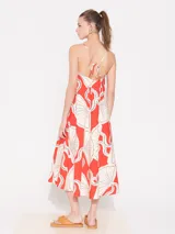 Vestido midi de algodón estampado color rojo con dibujos de abanicos en blanco y negro. Tiene escote en V, breteles finos regulables, espalda baja y bolsillos laterales.