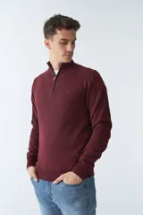 Sweater verde con medio cierre, tejido en buttoné, de manga larga y calce regular.