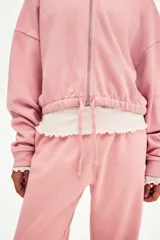 Jogging rosado de felpa con cintura elástica y cordón ajustable, de corte holgado y piernas amplias con bolsillos laterales.