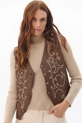 Chaleco marrón de simil cuero con bordado en color crema, cuello en V y cierre frontal con botones.
