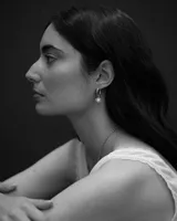Aros de plata con diseño irregular, argolla articulada y dije colgante con perla de río engarzada.
