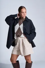 Sobrecamisa color beige de gabardina con cuello camisero, cierre frontal con botones a presión, dos bolsillos de parche en el pecho y corte holgado.