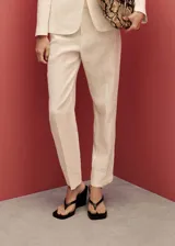 Pantalón de lino color blanco, de corte recto y tiro alto, con bolsillos laterales y traseros, y cierre oculto.