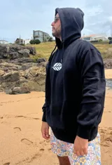 Hoodie negro con cordones ajustables y estampado de una hoja blanca en el frente.