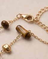 Pulsera de cadena fina dorada con piedras naturales ojo de tigre marrones intercaladas.