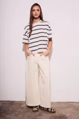 Remera de algodón color crudo con rayas horizontales negras, corte holgado y mangas cortas.