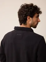 Campera de polar color beige con cierre frontal completo y cuello alto. Presenta un bolsillo en el pecho con cierre y detalle de parche con logo. El diseño combina paneles de tejido polar con detalles en tejido técnico en la zona del pecho.