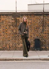 Cardigan de punto jaspeado con cierre frontal de cremallera, cuello perkins y manga larga.