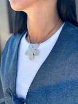 Chaleco de jean azul con cierre frontal mediante lazos ajustables, sin mangas y corte recto.