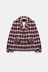 Blazer Zara Woman Collection de corte entallado con bajo peplum, confeccionada en tejido de mezcla de algodón con estampado de cuadros en tonos rojo, azul marino y blanco. Presenta cuello solapa, manga larga, bolsillos delanteros y cierre frontal con botones metálicos en relieve.