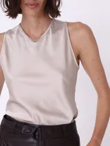 Remera básica de raso color visón, sin mangas y escote en V.