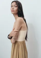 Vestido midi combinado con tirantes finos ajustables, escote recto y diseño con bajo abullonado estilo globo. Cuenta con cuerpo de punto en tono crudo y falda de tejido modal en tono tostado.