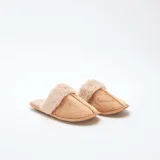 Pantuflas tipo mule color beige, confeccionadas en material efecto gamuza con borde y forro interior de pelo sintético suave.