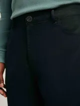 Pantalón de gabardina en color negro, con corte slim fit, cierre de botón y cremallera, y bolsillos laterales y traseros.