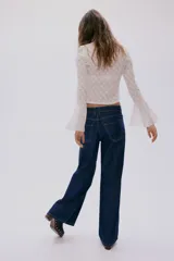 Jean de cinco bolsillos en denim rígido, de corte wide leg y tiro regular, con piernas amplias y costuras en contraste.