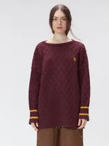 Sweater de cuello redondo con diseño de tejido en relieve de rombos, manga larga y calce holgado. Presenta logo bordado en el pecho y aberturas laterales en el ruedo.