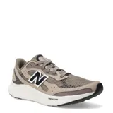 Championes de running New Balance con tecnología Fresh Foam en la entresuela para mayor amortiguación. Presentan un diseño en tonos marrones con detalles en negro y blanco, confeccionados en malla transpirable y refuerzos sintéticos, con el logo N característico en los laterales.