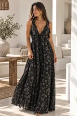 Vestido largo negro con bordados metalizados dorados, escote en V pronunciado, tirantes ajustables con borlas y falda amplia con movimiento fluido.