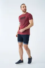 Bermuda de jean azul oscuro con diseño de cinco bolsillos, cierre de cremallera y botón, y detalle de botamanga doblada.