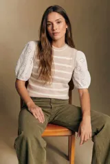 Chaleco de punto sin mangas con diseño de rayas horizontales en tonos beige y blanco, cuello redondo y terminaciones acanaladas.