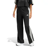 Pantalón de mujer Adidas tipo jogging en color negro, con diseño de malla transpirable, corte ancho y franjas blancas laterales con las clásicas tres tiras de la marca. Cuenta con cintura elástica con cordón de ajuste y logo bordado en la pierna.