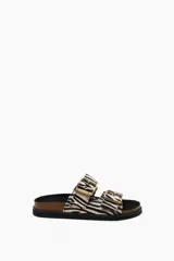 Sandalias planas con estampado de cebra, suela de corcho y hebillas doradas.