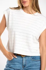 Remera blanca de algodón con textura de puntos calados horizontales, corte al cuerpo y mangas cortas tipo mariposa.