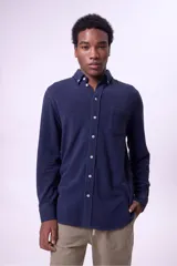 Camisa azul marino de manga larga con cuello abotonado y bolsillo en el pecho.