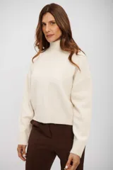 Sweater de punto con cuello alto, manga larga y corte holgado.