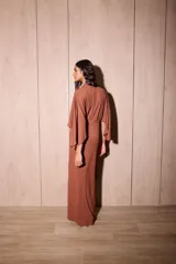 Vestido largo marrón tipo kimono en crepé texturado, con mangas amplias abiertas y tiras ajustables para atar en la cintura.