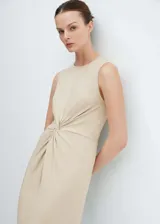 Vestido midi de algodón, color beige, con cuello redondo, sin mangas y detalle de nudo frontal que genera un ligero drapeado.
