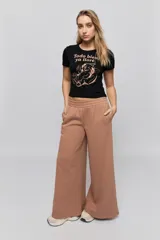 Remera negra de corte corto con cuello redondo y mangas cortas. Estampado frontal en tono rosado con la frase "Todo bien ya lloré" y una ilustración de un oso.