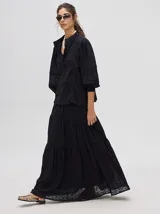 Camisa de broderie de algodón color negro, con diseño de calados, cuello mao con cierre de botones, mangas abullonadas con puños fruncidos y detalles de galones con transparencias.