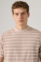 Remera Levi's de corte holgado con diseño de rayas horizontales en tonos beige y rosado. Presenta cuello redondo y un pequeño logo bordado en el pecho.