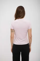 Remera de manga corta, color lila claro, con cuello redondo y calce ajustado al cuerpo.