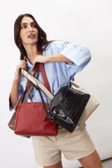 Bandolera compacta y semirrígida de cuero vacuno con cierre superior, ideal para llevar cruzada.
